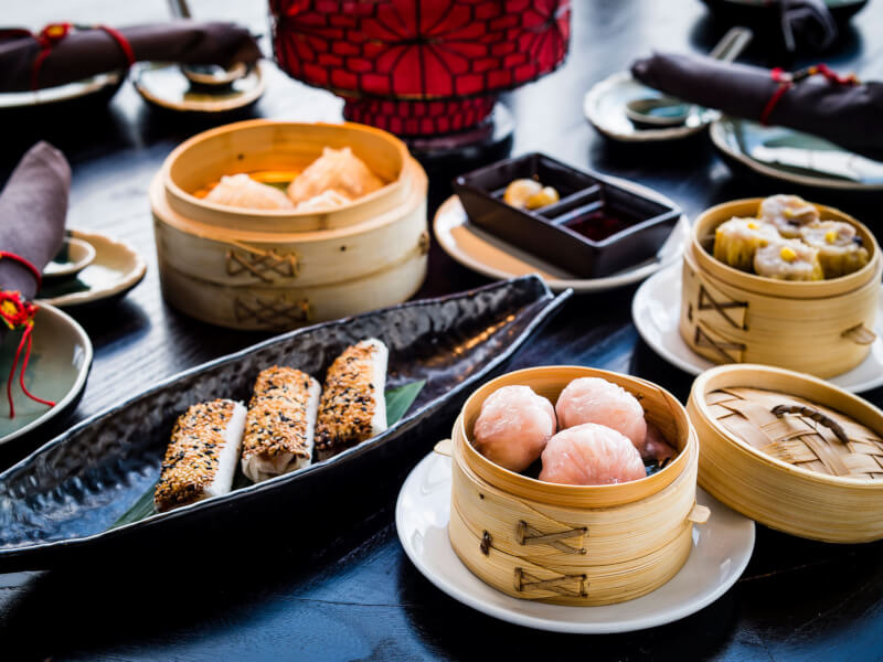 A table laid with various dishes, including a plate of dumplings